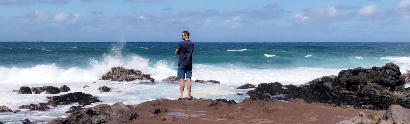 Jason standing at the edge of the Pacific Ocean in Maui, Hawaii